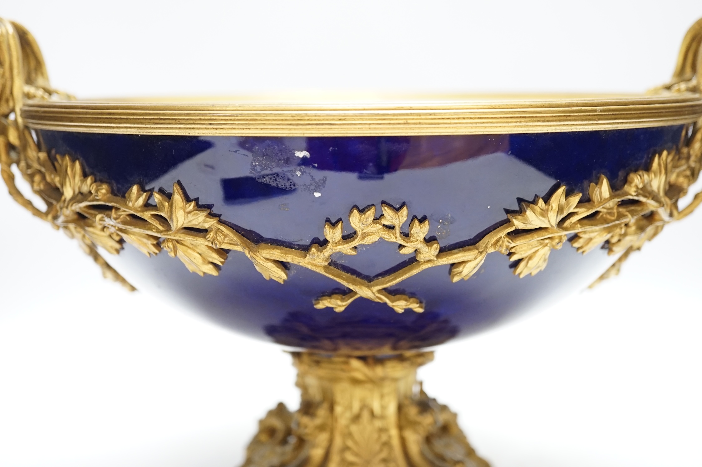 A large Louis XVI style ormolu and porcelain double handled centre dish, 27.5cm high, 31cm diameter